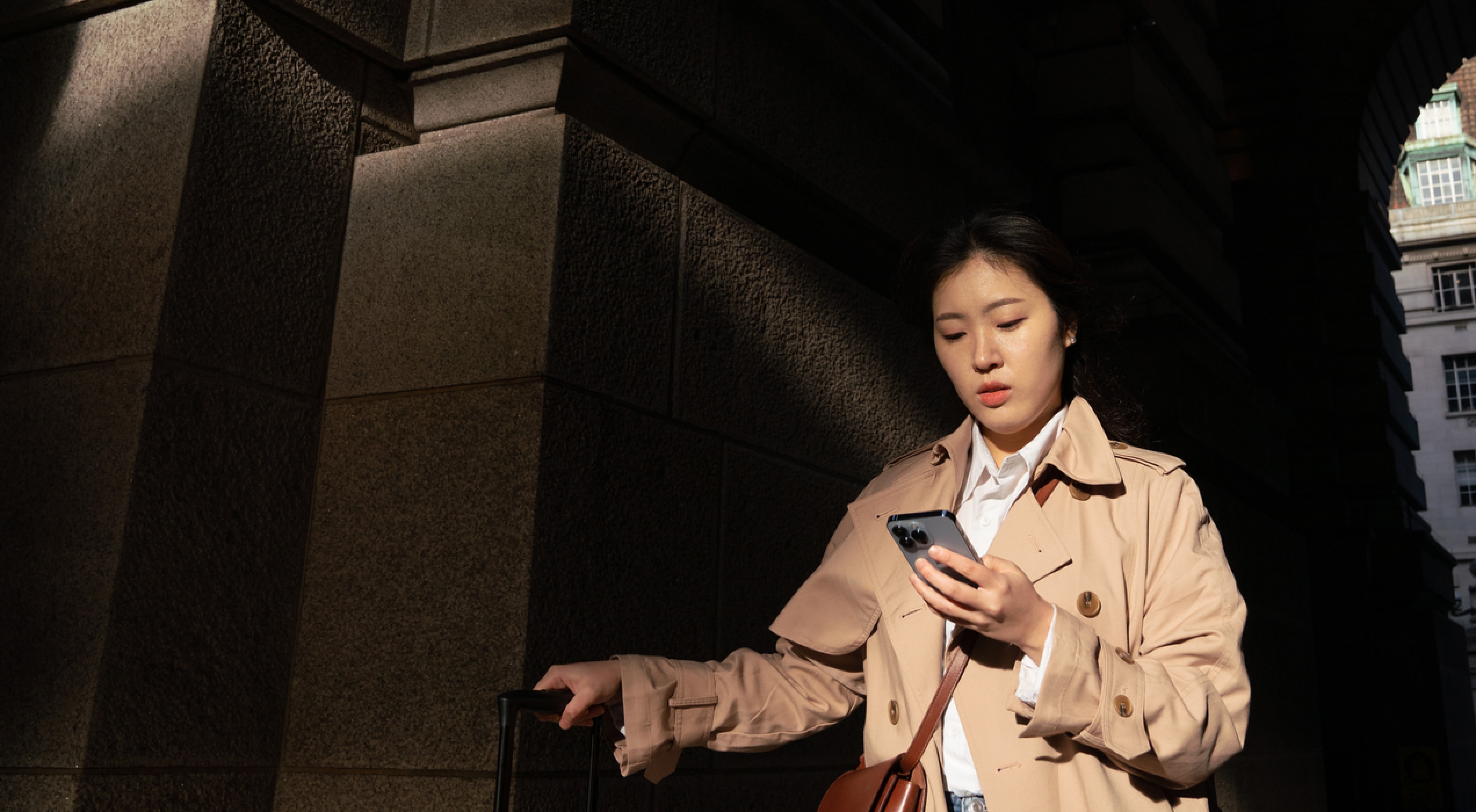 A woman sitting on her sofa checks the Bitstack app on her phone